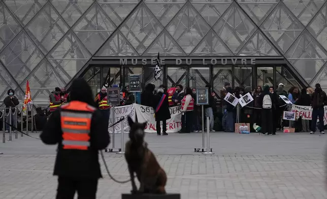 Workers block the entrance of the Louvre museum during a protests against rising living costs, in Paris, Monday, Oct. 19, 2026. (AP Photo/Christophe Ena)
