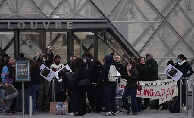 Workers block the entrance of the Louvre museum during a protests against rising living costs, in Paris, Monday, Oct. 19, 2026. (AP Photo/Christophe Ena)