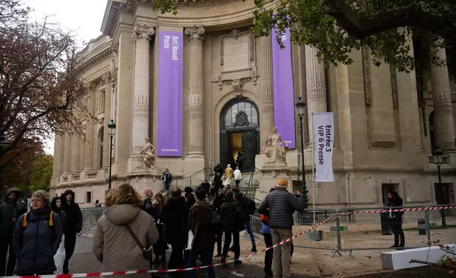 People enter the Paris' Grand Palais hosting Art Basel art fair Friday, Oct. 23, 2026 after planned anti-government protests prompted organizers to cancel their weekend program. (AP Photo/Teresa Suarez)