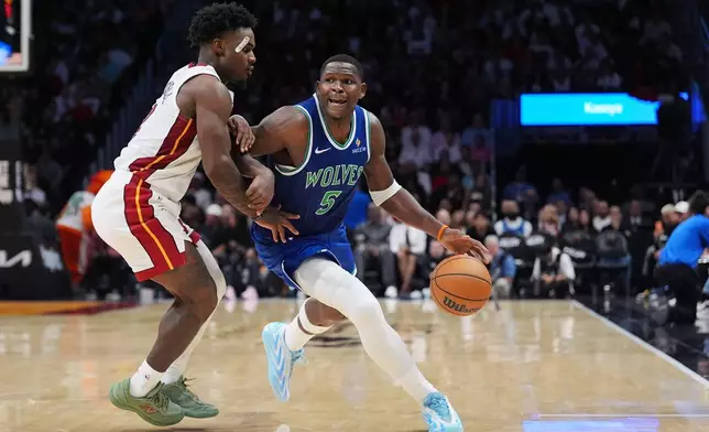 Minnesota Timberwolves guard Anthony Edwards (5) drives past Miami Heat guard Davion Mitchell during the second half of an NBA basketball game, Wednesday, Oct. 21, 2026, in Miami. (AP Photo/Rebecca Blackwell)