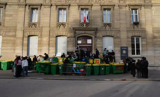 Students block the entrance of the high school Arago as they protest against under-resourced schools in Paris, Friday, Oct. 2, 2026. (AP Photo/Aurelien Morissard)