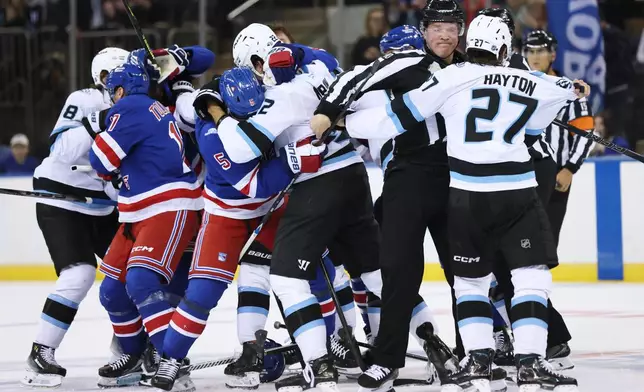 Referees break up a fight between New York Rangers and Utah Mammoth players during the first period of an NHL hockey game, Sunday, Oct. 4, 2026, in New York. (AP Photo/Heather Khalifa)