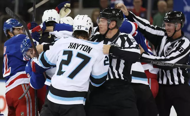 Referees break up a fight between New York Rangers and Utah Mammoth players during the first period of an NHL hockey game, Sunday, Oct. 4, 2026, in New York. (AP Photo/Heather Khalifa)