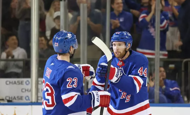 New York Rangers defenseman Vladislav Gavrikov (44) points to teammate Adam Fox (23) after scoring during the first period of an NHL hockey game against the Utah Mammoth, Sunday, Oct. 4, 2026, in New York. (AP Photo/Heather Khalifa)