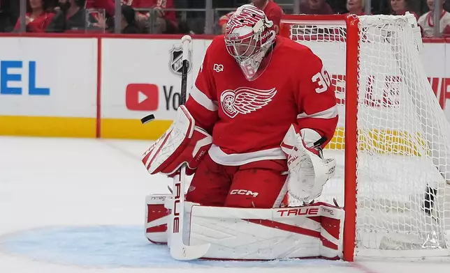 Detroit Red Wings goaltender John Gibson stops a New Jersey Devils shot in the first period of an NHL hockey game Tuesday, Oct. 13, 2026, in Detroit. (AP Photo/Paul Sancya)