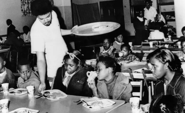 FILE - Bill Whitfield, a member of the Black Panther chapter in Kansas City, serves free breakfast to children on April 16, 1969, before they go to school. (AP Photo/William Straeter, File)