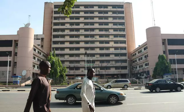 People walk past the Federal Ministry of Health in Abuja, Nigeria, Wednesday, Oct. 21, 2026. (AP Photo/Afolabi Sotunde)