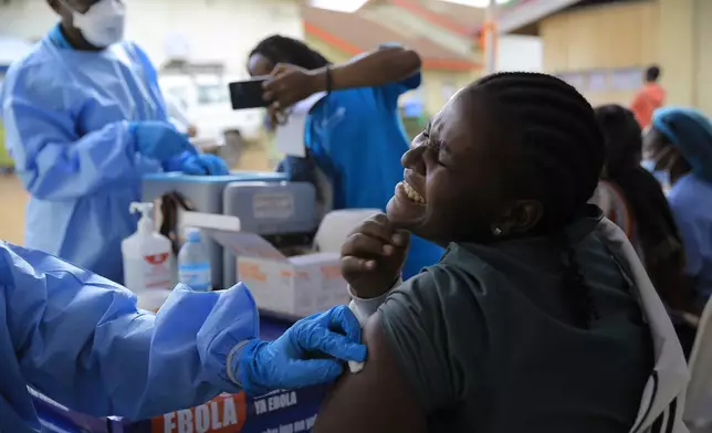 A health care worker reacts while receiving a dose of Ervebo vaccine against the Ebola virus in Beni, North Kivu province, eastern Congo, Friday, Oct. 16, 2026. (AP Photo/Sebastien Kitsa Musayi)