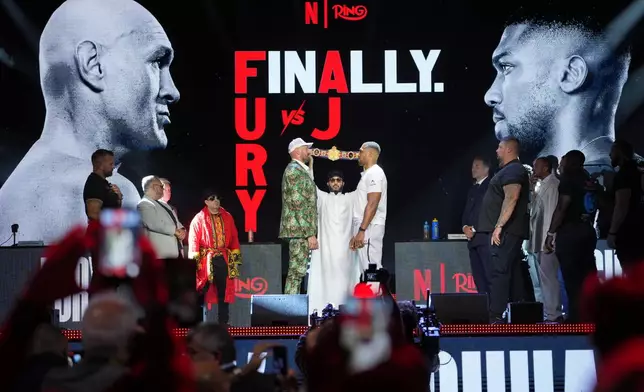 Tyson Fury, left, and Anthony Joshua, right, face off after a Press Conference in London, Wednesday, Sept. 30, 2026, to promote their upcoming fight which will take place at the Principality Stadium in Cardiff on Dec.11.(AP Photo/Kin Cheung)