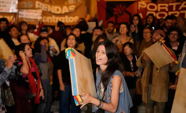 Protesters gather and shout slogans during a demonstration demanding affordable housing outside Portugal's Parliament in Lisbon, Tuesday, Oct. 27, 2026. (AP Photo/Armando Franca)