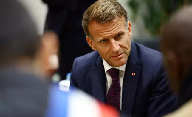 French President Emmanuel Macron meets community members at the town hall in Trappes, near Paris, France, Friday Oct. 23, 2026, after a shooting in the Parisian suburb left one person dead and several others wounded. (Hannah McKay/Pool Photo via AP)