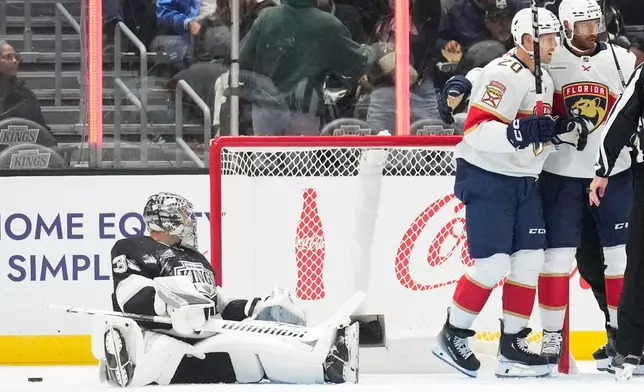 Florida Panthers center Lars Eller, second from right, celebrates his goal with defenseman Seth Jones, right, as Los Angeles Kings goaltender Darcy Kuemper sits in the ice during the second period of an NHL hockey game Tuesday, Oct. 6, 2026, in Los Angeles. (AP Photo/Mark J. Terrill)