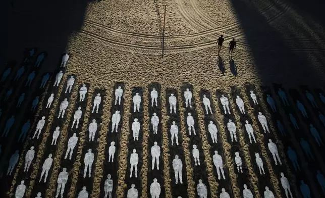 People walk past an installation marking the third anniversary of the Oct. 7, 2023, Hamas-led attack on Israel, on the beachfront in Tel Aviv, Israel, Wednesday, Oct. 7, 2026. (AP Photo/Oded Balilty)