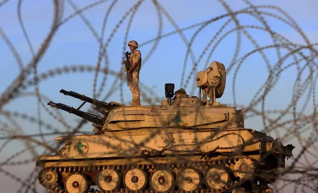 A Jordanian soldier stands atop an air defense armored vehicle while guarding Jordan's eastern border with Syria near Deir al Gin, about 220 kilometers (137 miles) east of Amman, Tuesday, Oct. 6, 2026. (AP Photo/Raad Adayleh)