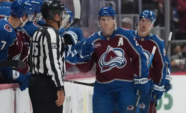 Colorado Avalanche center Nathan MacKinnon, right, is congratulated as he passes the team box after scoring a power-play goal against the Los Angeles Kings in the second period of an NHL hockey game Wednesday, Sept. 30, 2026, in Denver. (AP Photo/David Zalubowski)
