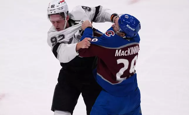 Colorado Avalanche center Nathan MacKinnon, right, jostles with Los Angeles Kings defenseman Brandt Clarke in the third period of an NHL hockey game Wednesday, Sept. 30, 2026, in Denver. (AP Photo/David Zalubowski)
