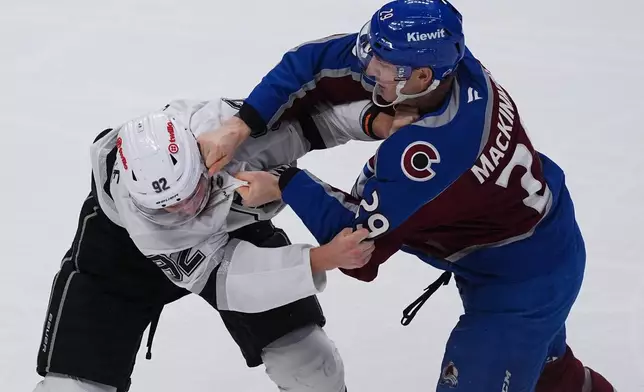 Colorado Avalanche center Nathan MacKinnon, right, punches Los Angeles Kings defenseman Brandt Clarke as they fight in the third period of an NHL hockey game Wednesday, Sept. 30, 2026, in Denver. (AP Photo/David Zalubowski)