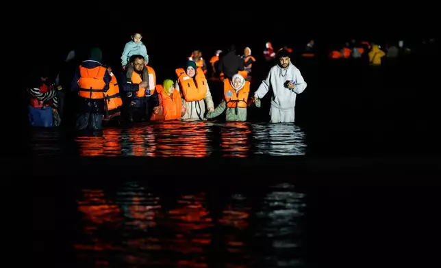 FILE - A group of migrants try to cross the channel from France to Britain on a dinghy boat, in Hardelot, northern France, Sept. 23, 2026. (AP Photo/Jean-Francois Badias, File)