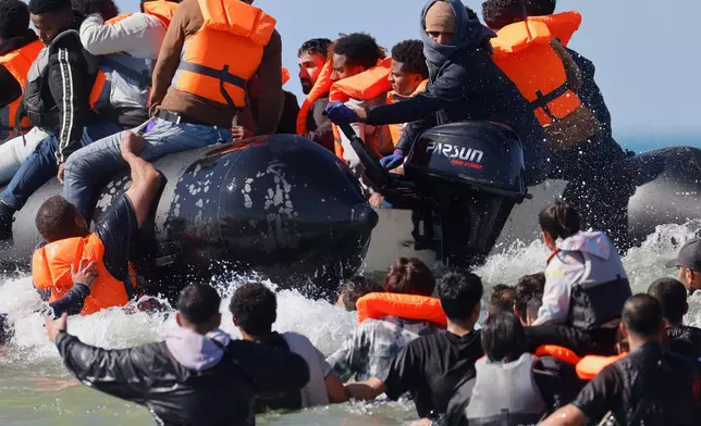 A group of migrants try to cross the channel from France to Britain on a dinghy boat, in Hardelot, northern France, Wednesday, Sept. 23, 2026. (AP Photo/Jean-Francois Badias)