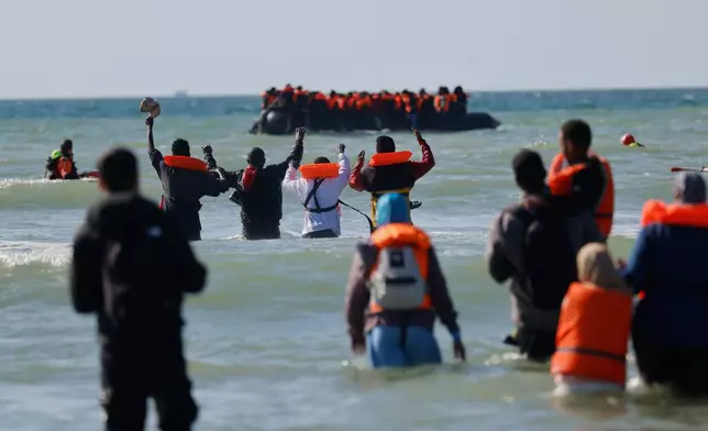 A group of migrants try to cross the channel from France to Britain on a dinghy boat, in Hardelot, northern France, Wednesday, Sept. 23, 2026. (AP Photo/Jean-Francois Badias)