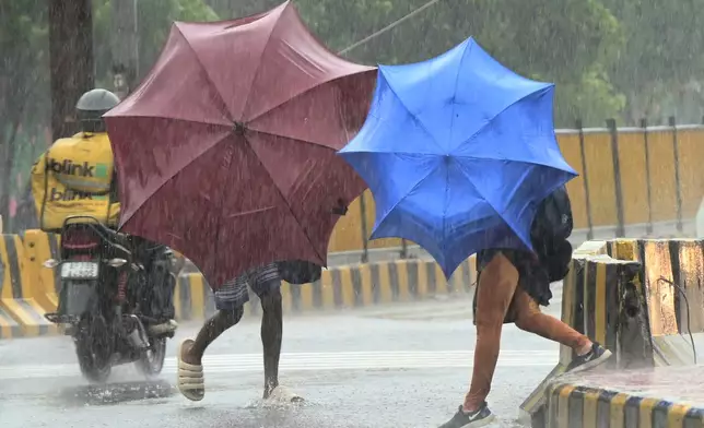 People use umbrellas to shield themselves from strong winds as Cyclone Arnab approaches the Andhra Pradesh coast, in Visakhapatnam, India, Tuesday, Oct. 27, 2026. (AP Photo)