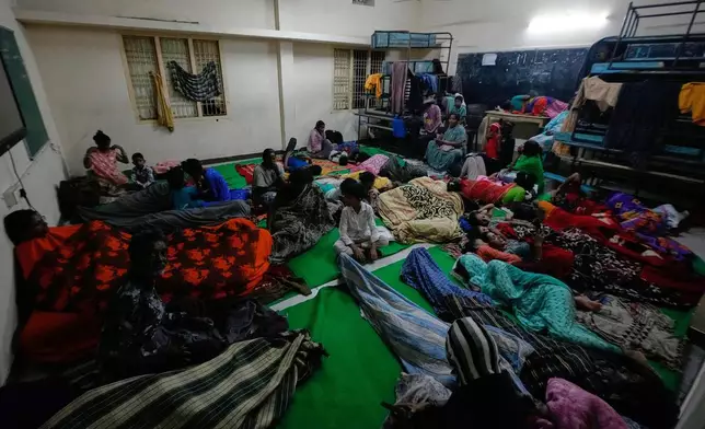 People gather at a temporary shelter set up inside a school as Cyclone Arnab approaches the Andhra Pradesh coast in Kakinada, India, late Tuesday, Oct. 27, 2026. (AP Photo/Mahesh Kumar A.)