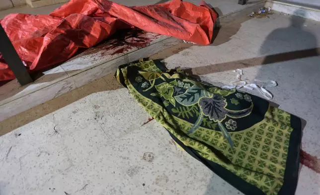 Blood stains the steps and pavement outside a Greek Orthodox church hours after gunmen opened fire during a funeral in Hamoud village, in Jordan's Karak governorate, Friday, Oct. 23, 2026. (AP Photo)