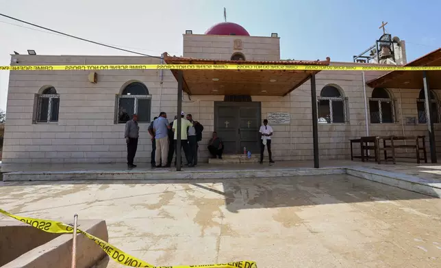 Cleaners and others gather outside St. George's Greek Orthodox Church a day after gunmen opened fire during a funeral in the village of Hamoud, in Jordan's Karak governorate, Saturday, Oct. 24, 2026. (AP Photo/Raad Adayleh)