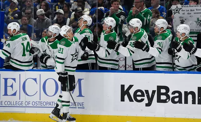Dallas Stars left wing Jason Robertson (21) celebrates with teamamtes after scoring during the first period of an NHL hockey game against the Buffalo Sabres, Thursday, Oct. 8, 2026, in Buffalo, N.Y. (AP Photo/Adrian Kraus)