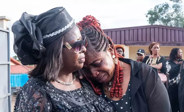 Mbatiabuh Regina Ngakum, sister of murdered woman Achiah Geraldine, is comforted as she grieves outside a mortuary chapel in Yaoundé, Cameroon, Friday, Sept. 18, 2026. (AP Photo/Angel Ngwe)