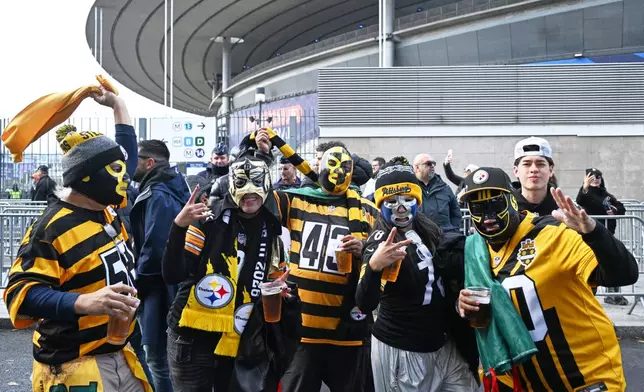 Supporters of the Pittsburgh Steelers pose for a photo outside the Stade de France stadium before the start of the NFL football game between Pittsburgh Steelers and New Orleans Saints in Saint-Denis, outside Paris, Sunday, Oct. 25, 2026. (AP Photo/Emma Da Silva)