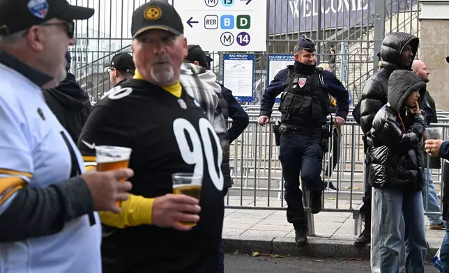 A police officer stands outside the Stade de France stadium before the start of the NFL football game between Pittsburgh Steelers and New Orleans Saints in Saint-Denis, outside Paris, Sunday, Oct. 25, 2026. (AP Photo/Emma Da Silva)