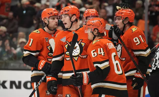 Anaheim Ducks right wing Beckett Sennecke, second from left, celebrates his goal with teammates during the second period of an NHL hockey game against the Vancouver Canucks Tuesday, Oct. 27, 2026, in Anaheim, Calif. (AP Photo/Gregory Bull)