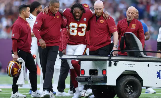 Washington Commanders wide receiver Jaylin Lane (83) is taken from the field injured during an NFL football game against Indianapolis Colts in London, Sunday, Oct. 4, 2026. (AP Photo/Ian Walton)