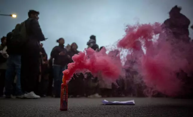A red smoke torch lies on the ground as thousands protest the killing of Kosovo-American woman Arlinda Zekaj, whose death sparked public outrage and renewed calls for accountability over violence against women, in Pristina, Kosovo, on Wednesday, Oct. 28, 2026. (AP Photo/Visar Kryeziu)