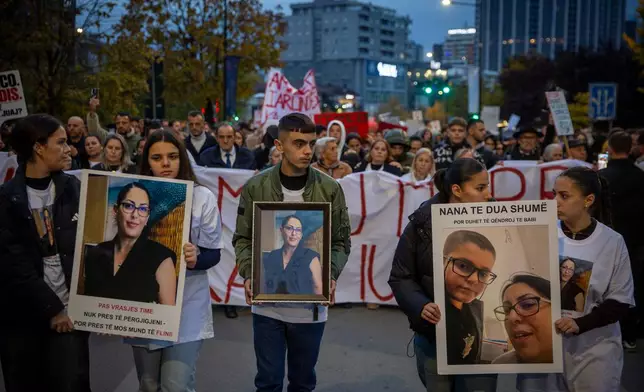 Family members of Arlinda Zekaj hold her picture during a protest in Pristina, Kosovo, as thousands gather to condemn the killing of the Kosovo-American woman, whose death sparked public outrage and renewed calls for accountability over violence against women, on Wednesday, Oct. 28, 2026. (AP Photo/Visar Kryeziu)