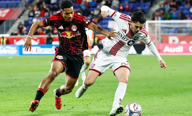 Toronto FC forward Lewis Morgan, right, fights for the ball against New York Red Bulls defender Justin Che, left, during an MLS soccer match Saturday, Oct. 17, 2026, in Harrison, N.J. (AP Photo/Eduardo Munoz Alvarez)