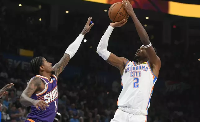 Oklahoma City Thunder guard Shai Gilgeous-Alexander, right, looks to shoot over Phoenix Suns guard Jalen Green, left, during the second half of an NBA basketball game, Monday, Oct. 26, 2026, in Oklahoma City. (AP Photo/Kyle Phillips)