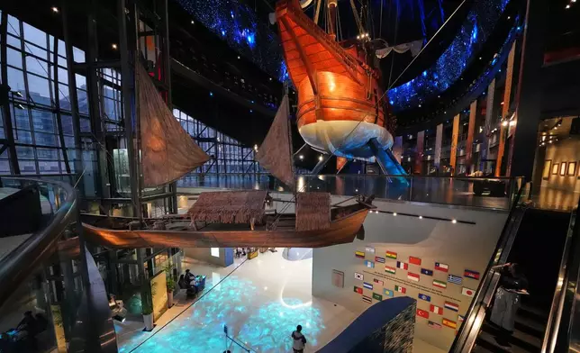 Visitors look at the 17th century Spanish galleon called Espiritu Santo, right, and a balangay called "mother boat', left, at the Museo del Galeon in Manila, Philippines on Friday, Aug. 28, 2026. (AP Photo/Aaron Favila)