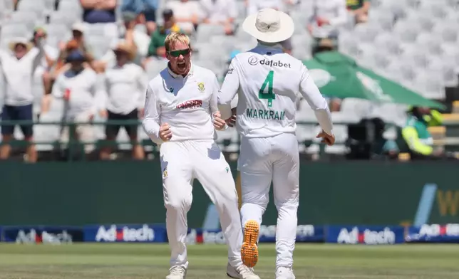 South Africa's Simon Harmer, left, celebrates with teammate Aiden Markram the wicket of Australia's Josh Inglis on day three of the third cricket test match between South Africa and Australia, in Cape Town, South Africa, Thursday, Oct. 29, 2026. (AP Photo/Halden Krog)