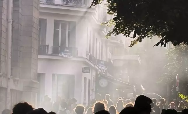 In this photo taken with a smartphone, high school students block the entrance of Voltaire high school to demand more resources, in Paris, Thursday, Oct. 1, 2026. (AP Photo/Nicolas Garriga)
