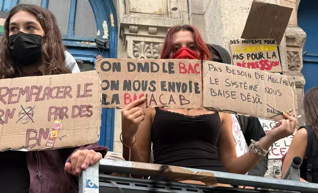 In this photo taken with a smartphone, high school students block the entrance of Voltaire high school to demand more resources, in Paris, Thursday, Oct. 1, 2026. (AP Photo/Nicolas Garriga)