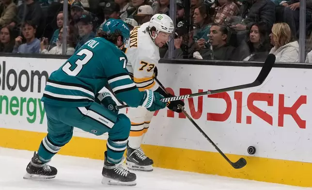 Boston Bruins defenseman Charlie McAvoy, right, reaches for the puck against San Jose Sharks center Tyler Toffoli during the first period of an NHL hockey game, Tuesday, Oct. 13, 2026, San Jose, Calif. (AP Photo/Jeff Chiu)