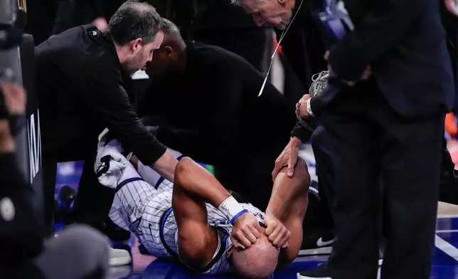 Orlando Magic guard Jalen Suggs, bottom, reacts after an injury during the second half of an NBA basketball game against the New York Knicks, Sunday, Oct. 25, 2026, in New York. (AP Photo/Yuki Iwamura)