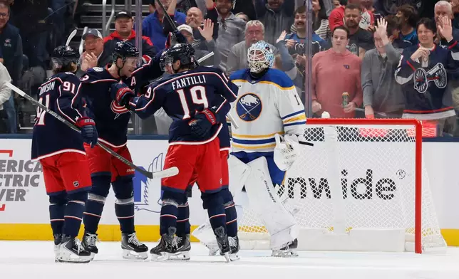 Columbus Blue Jackets players celebrate after a goal against Buffalo Sabres' Ukko-Pekka Luukkonen, right during the first period of an NHL hockey game, Thursday, Oct. 1, 2026, in Columbus, Ohio. (AP Photo/Jay LaPrete)