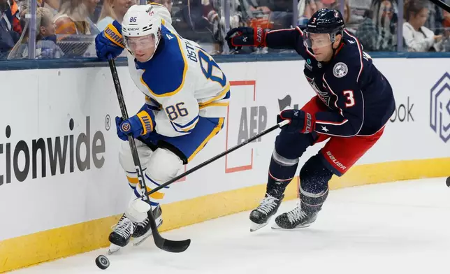 Buffalo Sabres' Noah Ostlund, left, keeps the puck away from Columbus Blue Jackets' Charlie Coyle, right, during the first period of an NHL hockey game, Thursday, Oct. 1, 2026, in Columbus, Ohio. (AP Photo/Jay LaPrete)