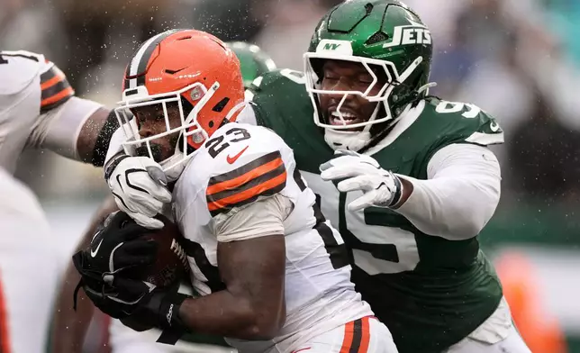 Cleveland Browns running back Raheim Sanders (23) is tackled by New York Jets defensive tackle Darrell Jackson Jr. (95) during the second half of an NFL football game, Sunday, Oct. 11, 2026, in East Rutherford, N.J. (AP Photo/Adam Hunger)