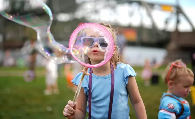 Ava Conda, 6, of Minneapolis, blows bubbles during the annual Harvest Festival, Sunday, Oct. 11, 2026, in Stillwater, Minn. (AP Photo/Ellen Schmidt)