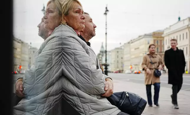 People wait for a bus at a bus stop in St. Petersburg, Russia, Friday, Oct. 16, 2026. (AP Photo/Dmitri Lovetsky)