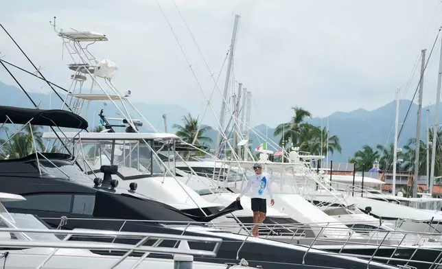 A man places a window covering on his boat as Hurricane Simon approaches Puerto Vallarta, Mexico, Saturday, Oct. 10, 2026. (AP Photo/Fernando Llano)